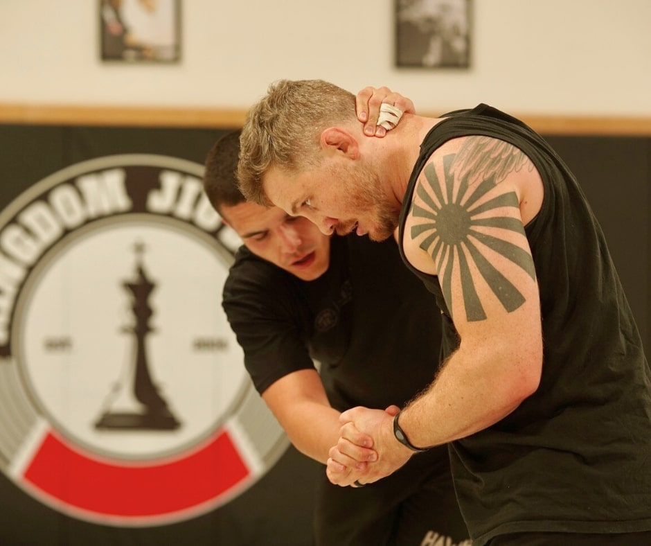 An instructor demonstrating a Jiu-Jitsu technique to a student during a class.